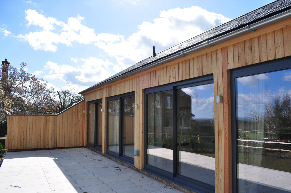 Steel framed barn conversion exterior with large glazed doors Kent - Vernacular Homes