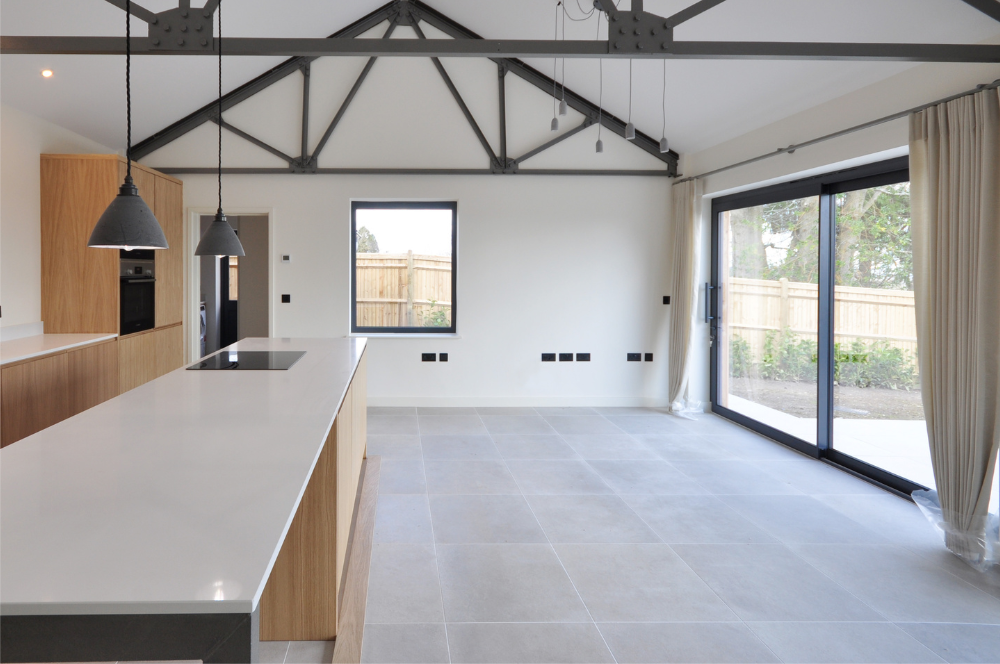 Steel framed barn conversion view across kitchen with large island Kent - Vernacular Homes